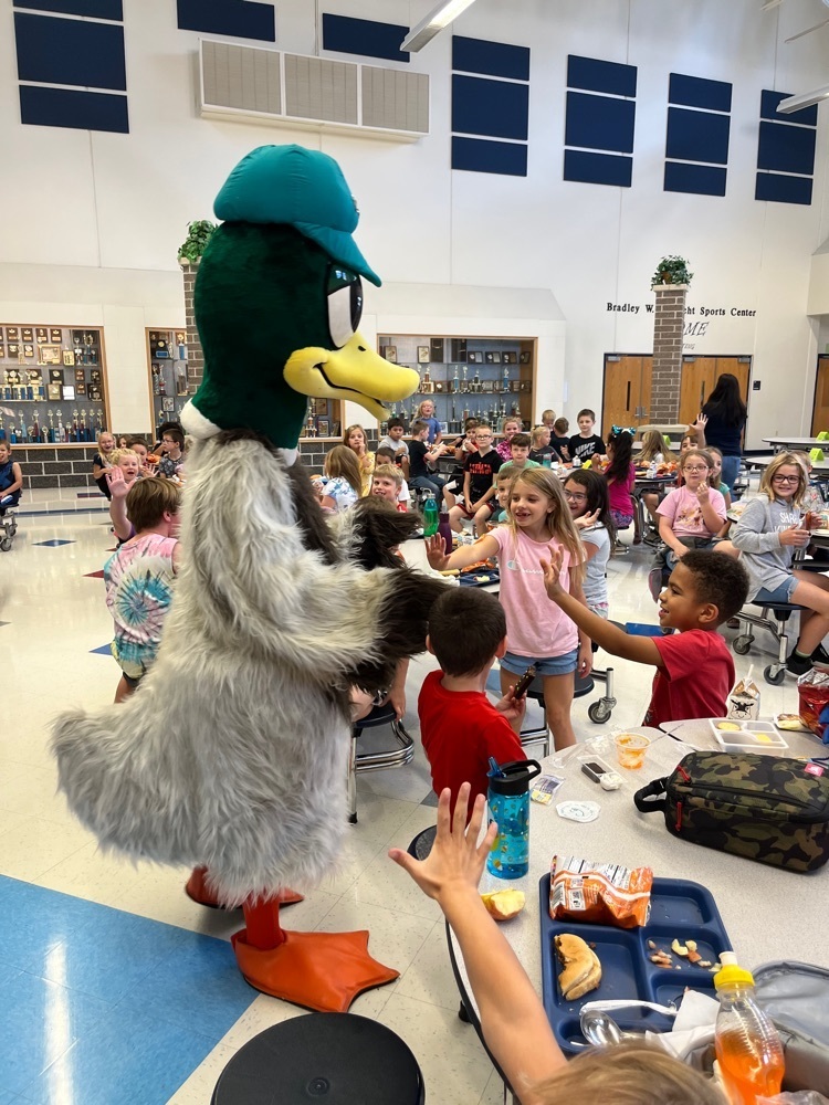 Leo the duck greets students eating lunch